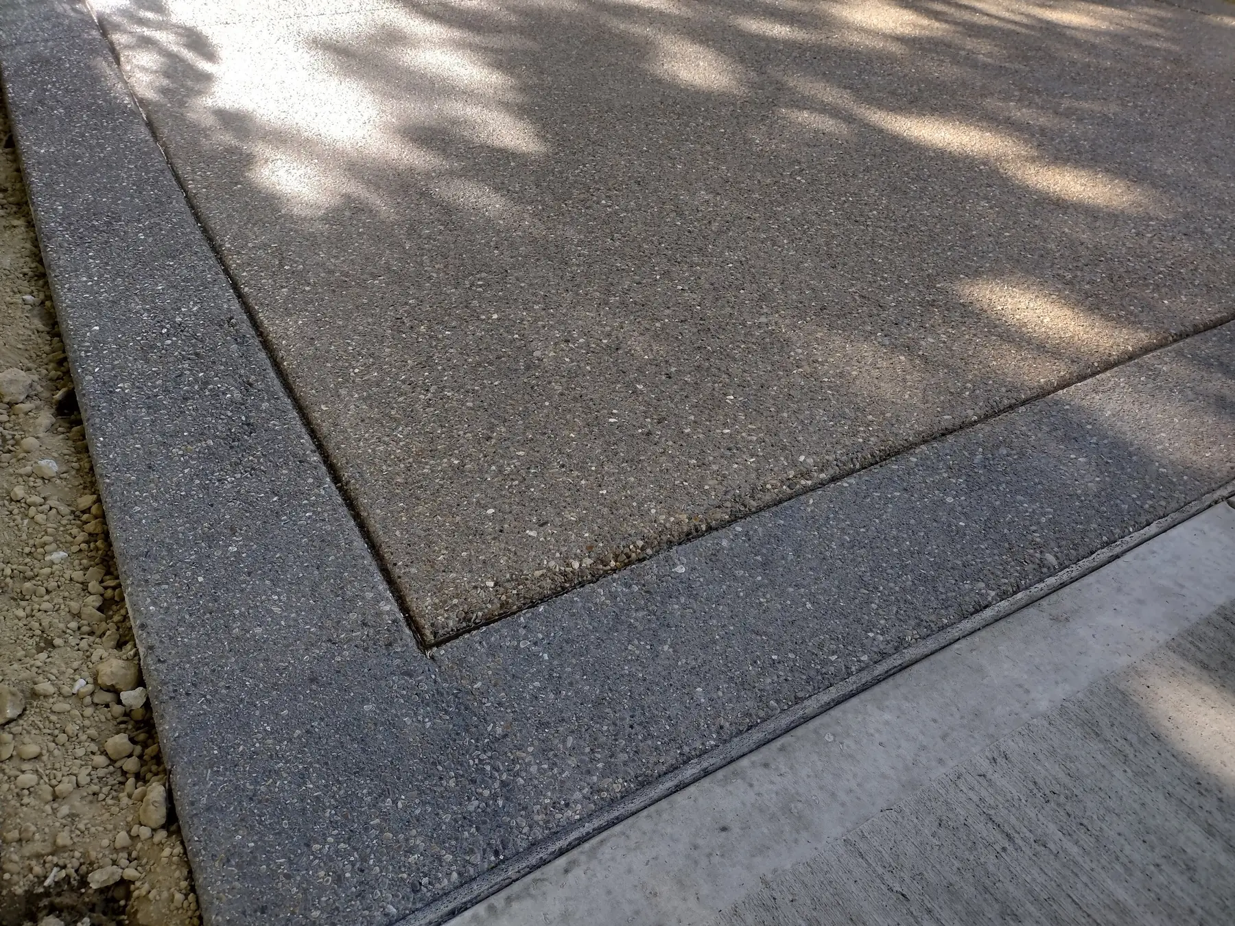 Dalle extérieure en béton désactivé, gravillons apparents et bordure lisse