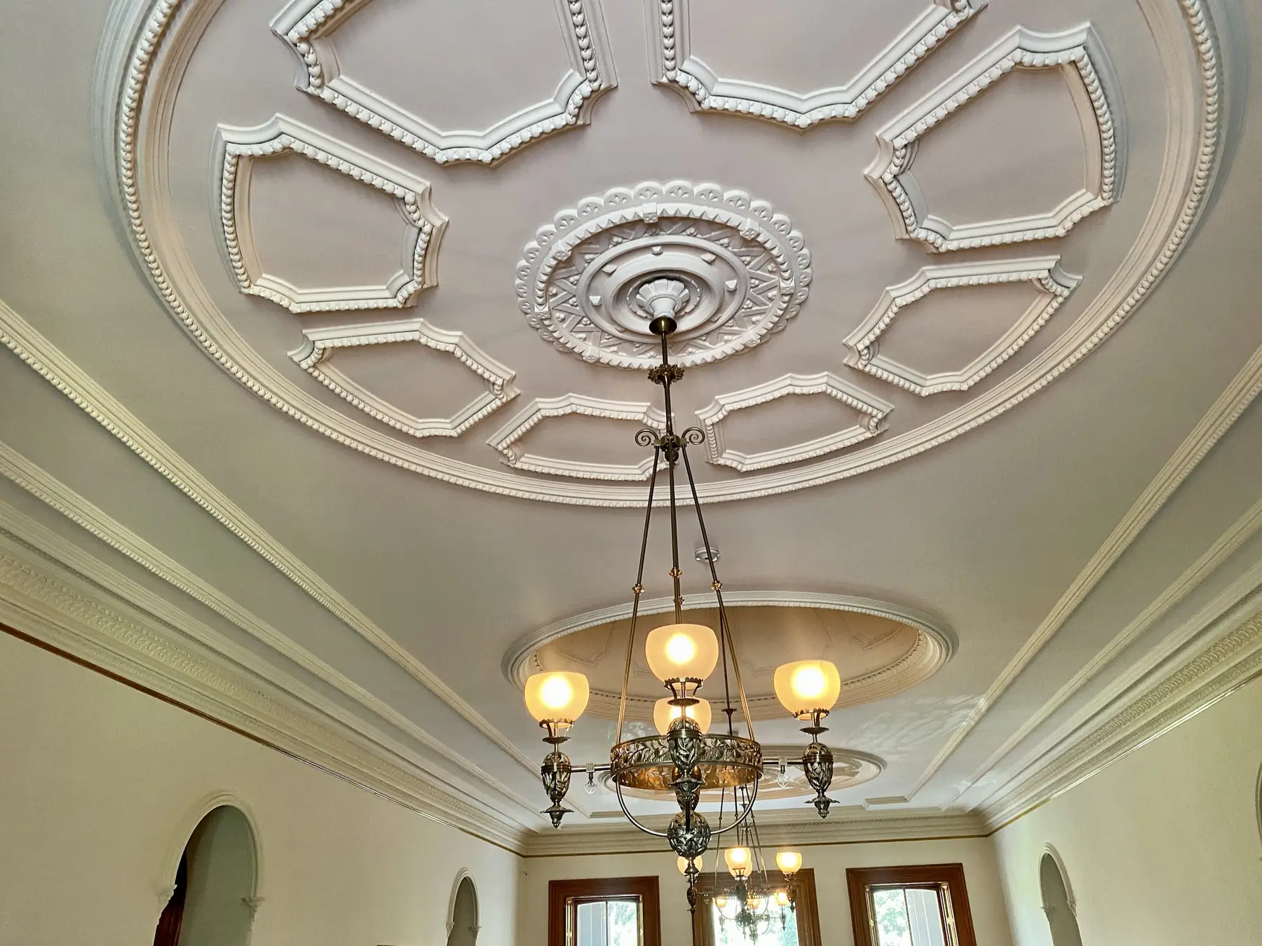 Plafond à moulures et rosace en plâtre, lustre suspendu au centre