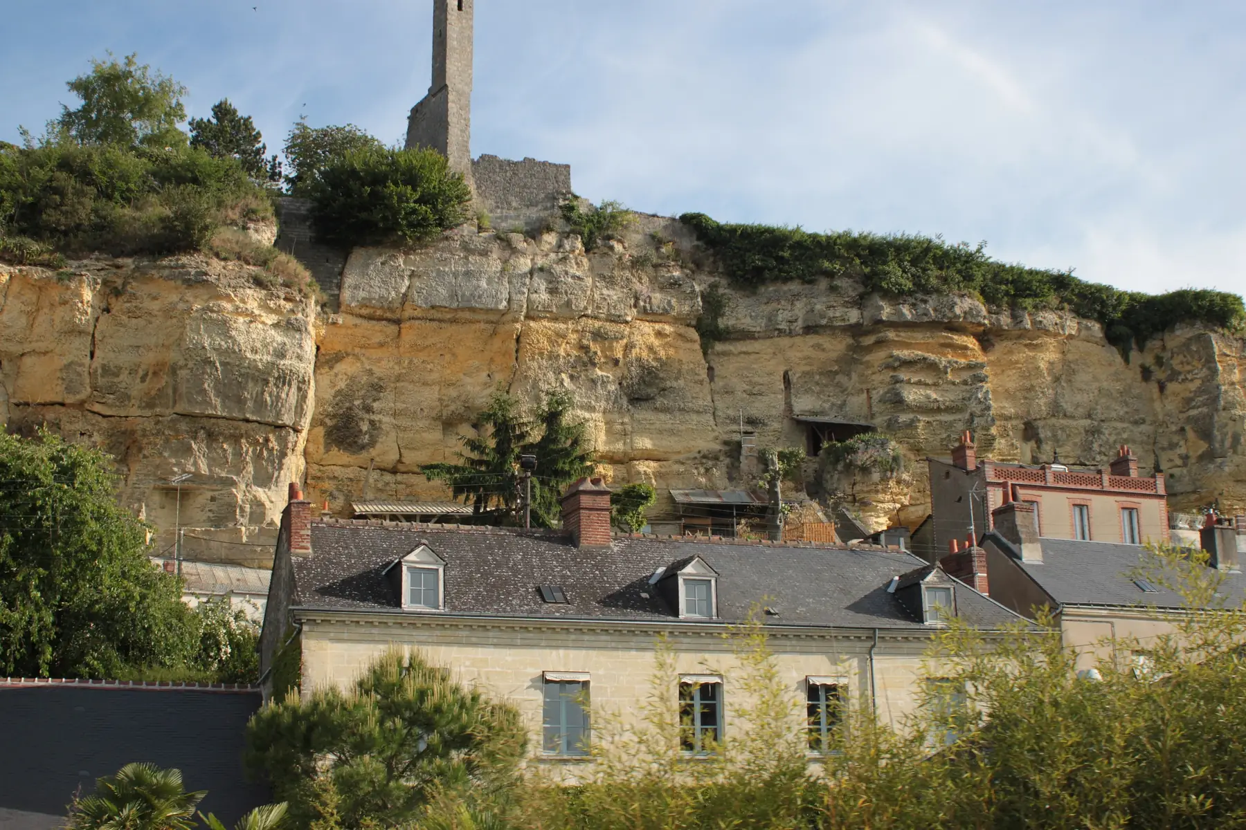 Coteau de tuffeau creusé de caves au-dessus de maisons couvertes d’ardoise, à Rochecorbon